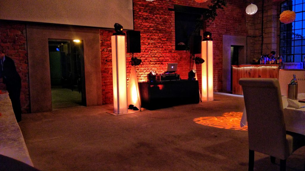 Hochzeitslocation mit DJ-Aufbau und warmem Licht
